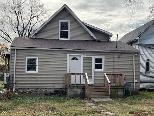 rear view of property featuring a lawn