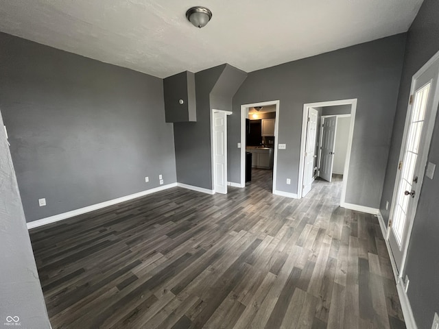 unfurnished living room with dark hardwood / wood-style floors and lofted ceiling