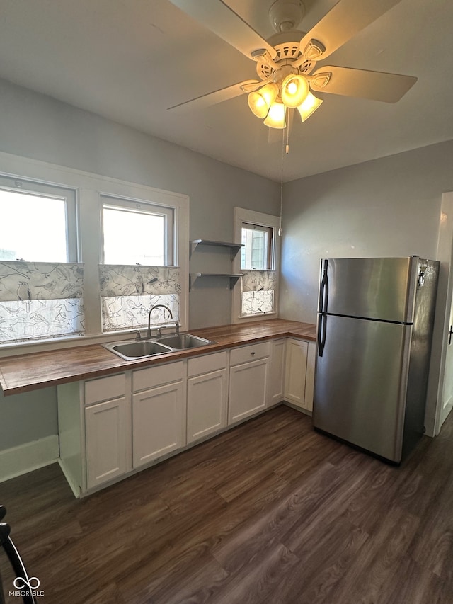 kitchen with white cabinets, sink, dark hardwood / wood-style floors, stainless steel refrigerator, and wood counters