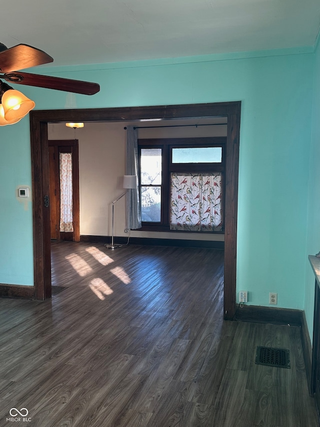 spare room with dark wood-type flooring and ceiling fan