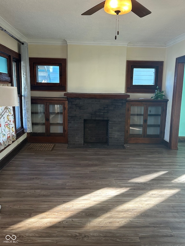 unfurnished living room featuring a fireplace, ceiling fan, crown molding, and dark hardwood / wood-style flooring