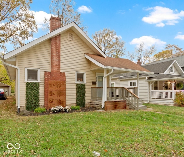 back of house featuring a porch and a yard