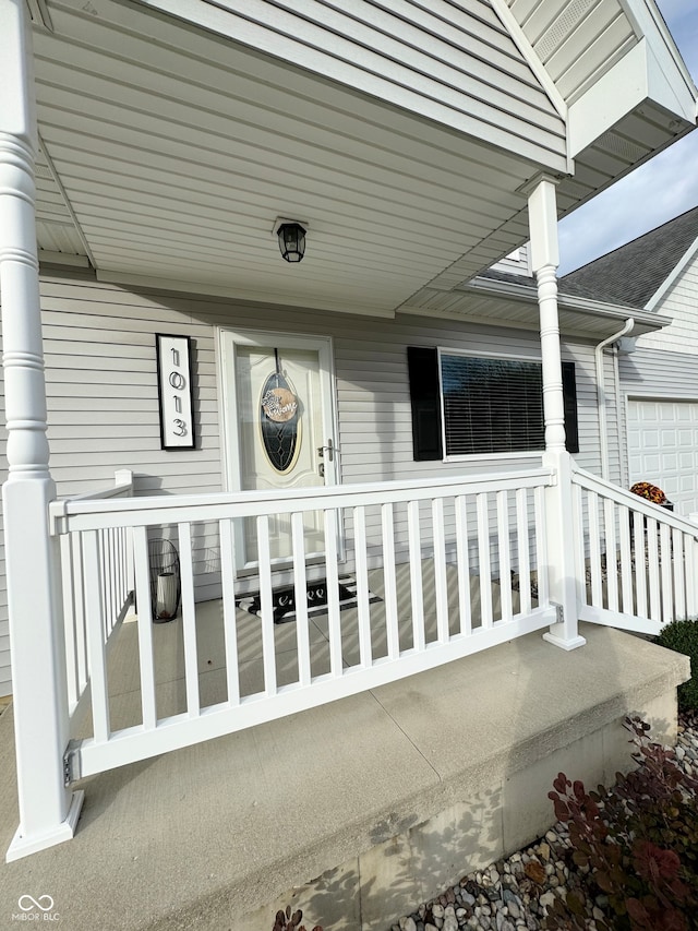 doorway to property featuring a garage and a porch