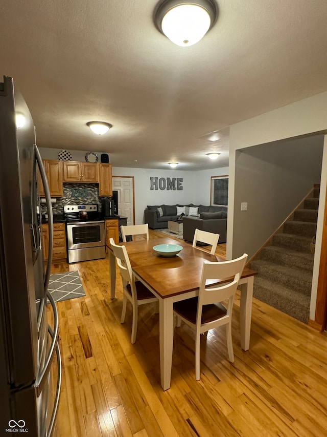 dining room featuring a textured ceiling and light hardwood / wood-style flooring