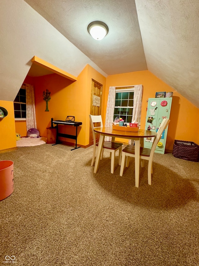 carpeted dining room featuring lofted ceiling and a textured ceiling