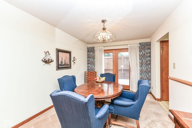 dining room with a notable chandelier, light colored carpet, and a textured ceiling