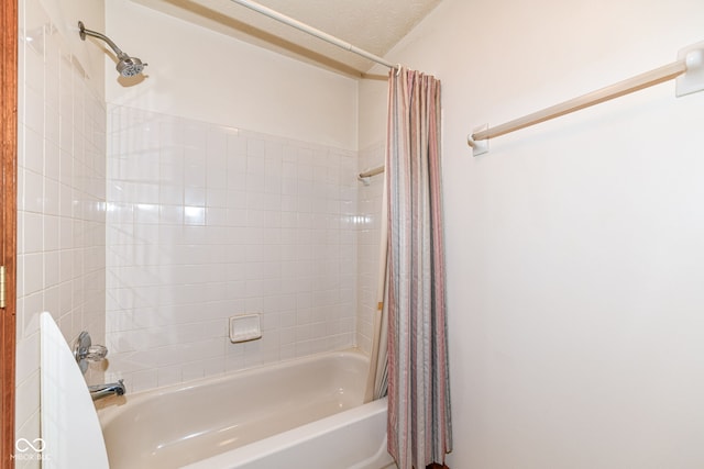 bathroom featuring a textured ceiling and shower / tub combo