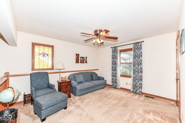 living area with ceiling fan and light colored carpet