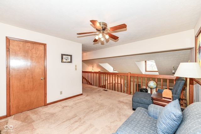 living area featuring ceiling fan, carpet floors, a textured ceiling, and a skylight