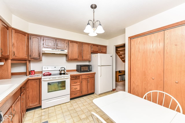 kitchen featuring a textured ceiling, white appliances, an inviting chandelier, and hanging light fixtures