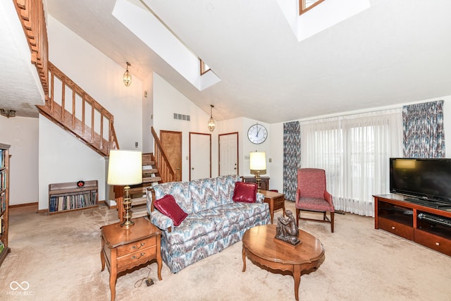 carpeted living room with high vaulted ceiling and a skylight