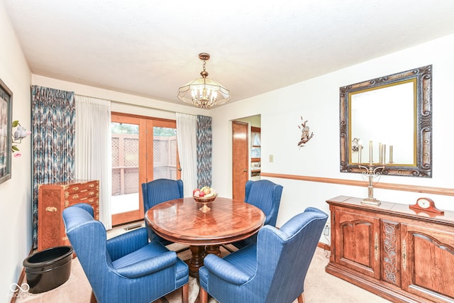 dining space with light colored carpet, a textured ceiling, and a notable chandelier