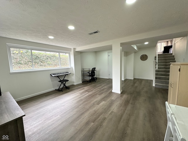 basement featuring hardwood / wood-style floors and a textured ceiling