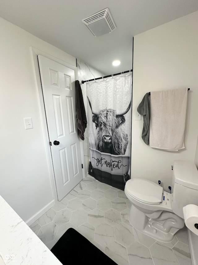 bathroom featuring a shower with shower curtain and toilet