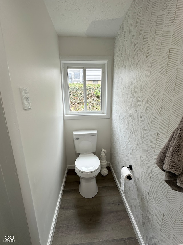 bathroom featuring toilet, a textured ceiling, and hardwood / wood-style flooring