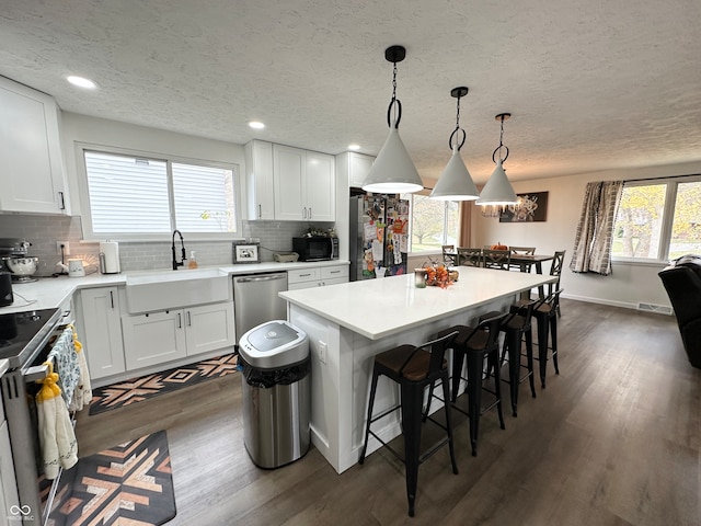 kitchen featuring white cabinetry, a wealth of natural light, sink, and a breakfast bar