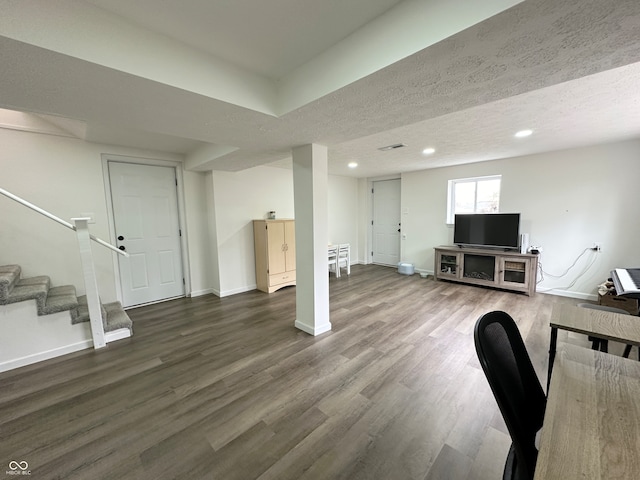 living room featuring dark hardwood / wood-style flooring and a textured ceiling