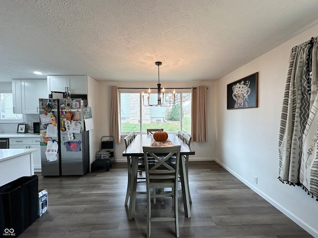 dining area with dark hardwood / wood-style flooring, a textured ceiling, and a notable chandelier