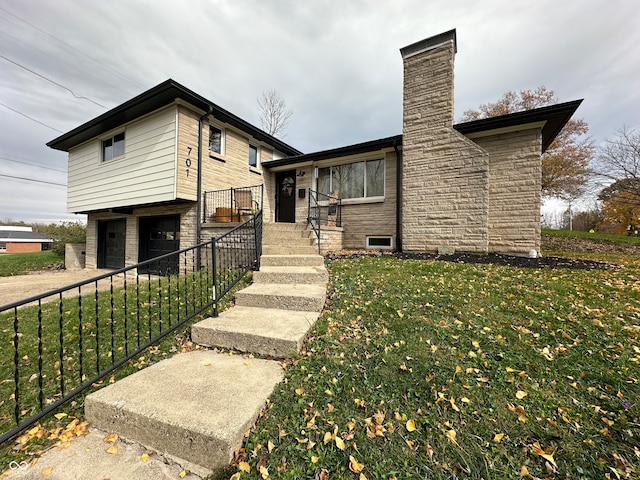 split level home featuring a garage and a front lawn