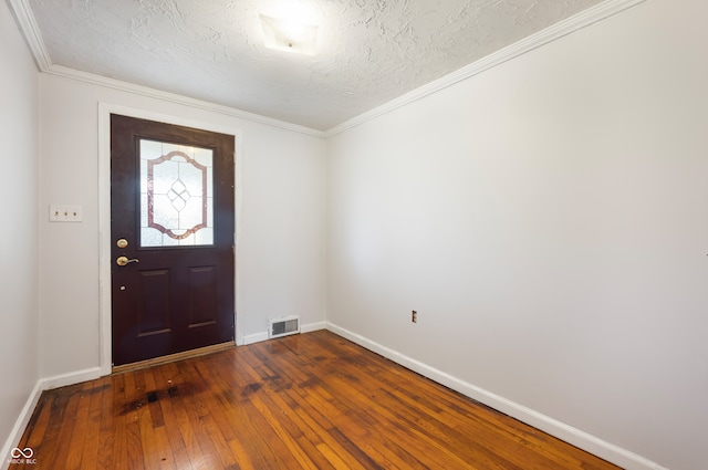 foyer featuring ornamental molding, wood-type flooring, and a textured ceiling