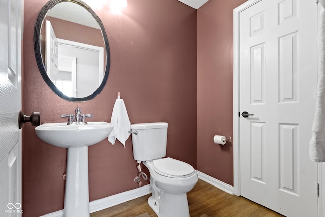 bathroom featuring sink, toilet, and hardwood / wood-style flooring