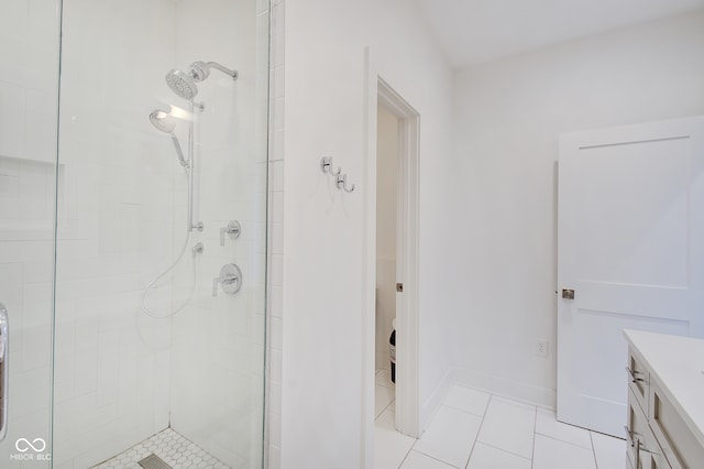 bathroom featuring vanity, tile patterned flooring, and a tile shower