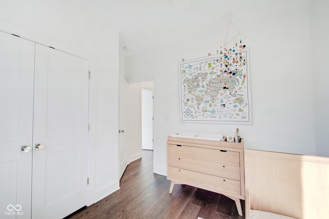 bedroom with dark wood-type flooring and a closet