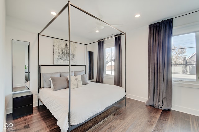 bedroom featuring multiple windows and dark hardwood / wood-style flooring