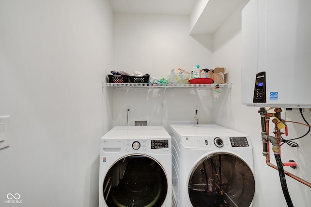 clothes washing area with washing machine and dryer and tankless water heater