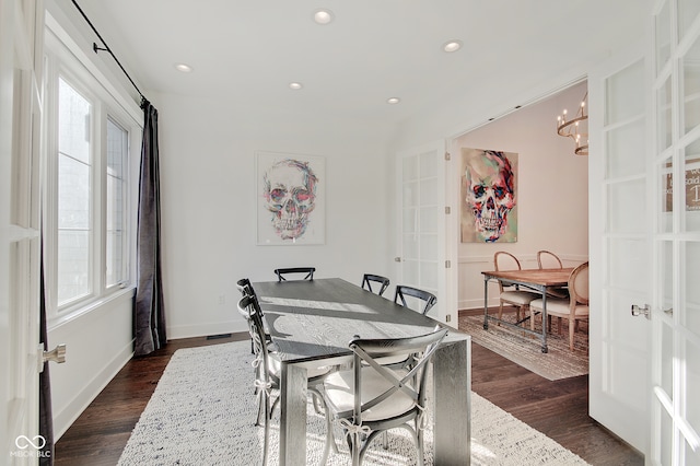 dining room with dark hardwood / wood-style flooring and a chandelier