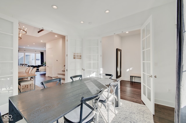 dining space featuring french doors, dark hardwood / wood-style flooring, and an inviting chandelier