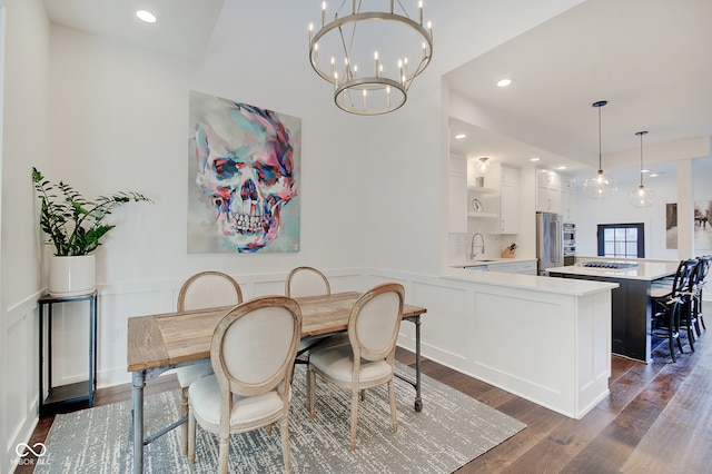 dining room featuring dark wood-type flooring, a chandelier, and sink