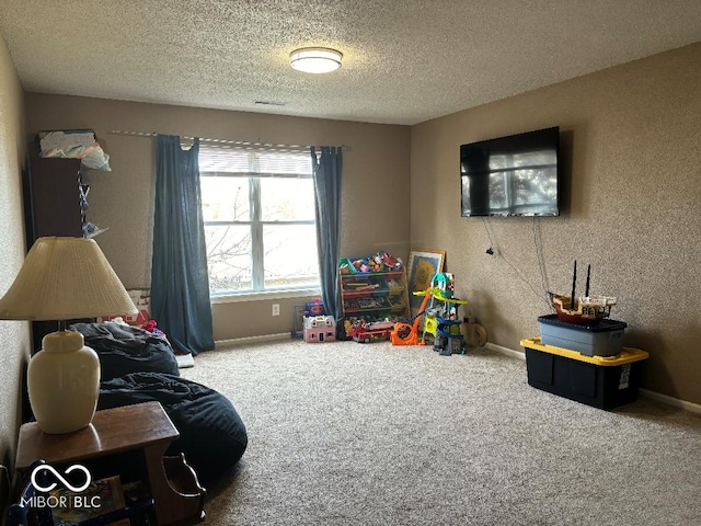 rec room with carpet floors, baseboards, and a textured ceiling