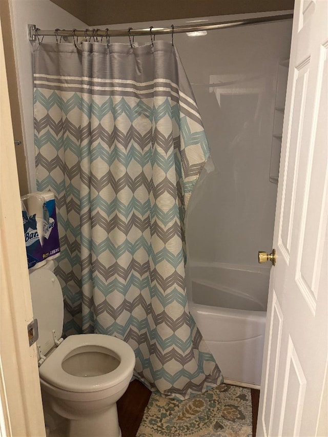 bathroom with shower / bath combination with curtain and toilet