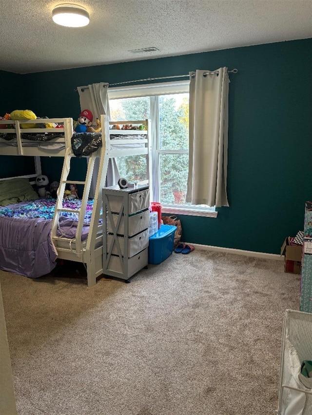 carpeted bedroom featuring a textured ceiling, visible vents, and baseboards