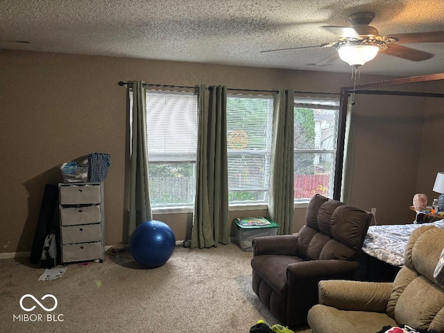 interior space featuring a ceiling fan, carpet flooring, and a textured ceiling