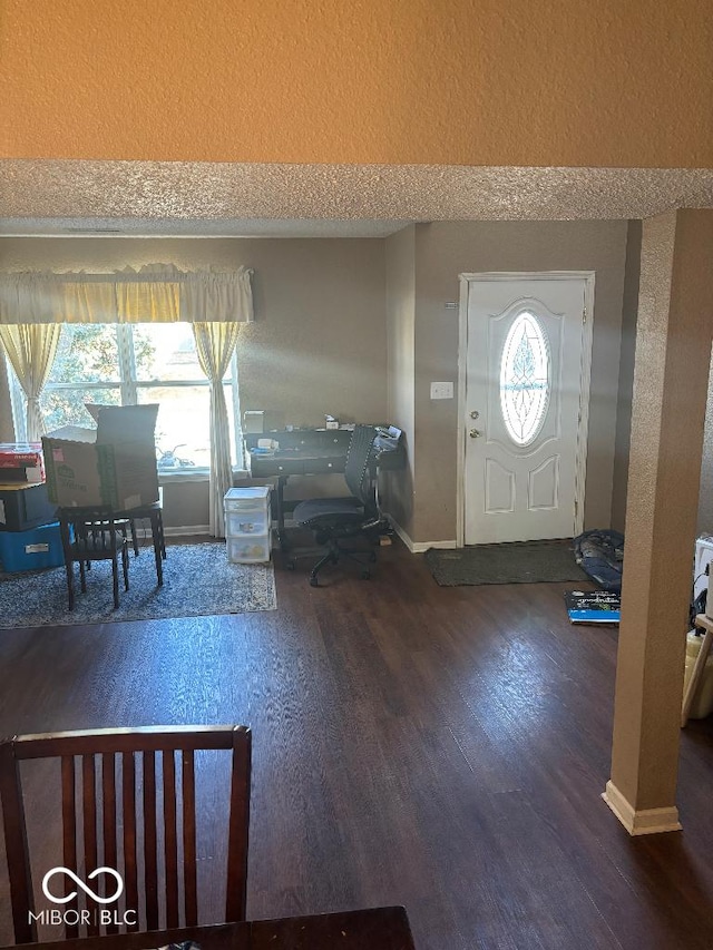 entrance foyer with a textured ceiling, baseboards, and wood finished floors