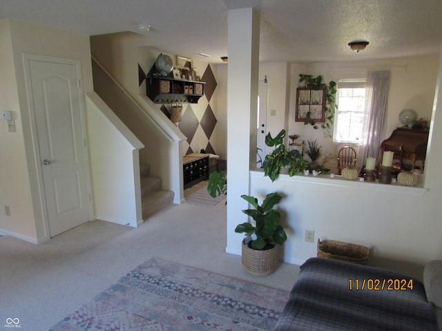 entrance foyer with a textured ceiling and light colored carpet