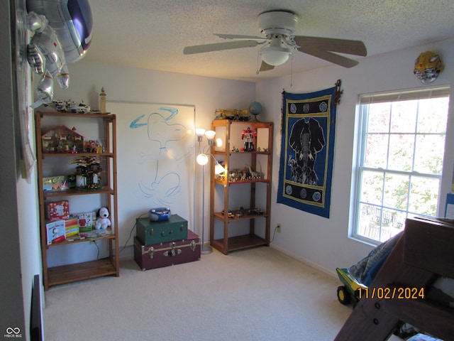 rec room with carpet, a textured ceiling, and ceiling fan