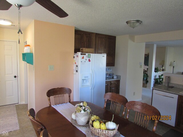 dining area featuring a ceiling fan, a textured ceiling, and light tile patterned floors