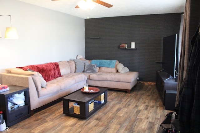 living room featuring dark wood-type flooring and ceiling fan