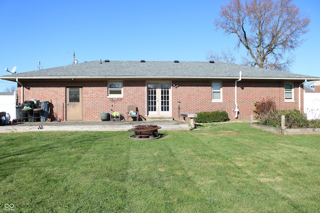 back of property featuring a lawn, a patio, and a fire pit