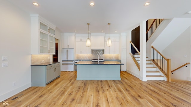 kitchen featuring light hardwood / wood-style flooring, sink, decorative light fixtures, white cabinets, and built in fridge