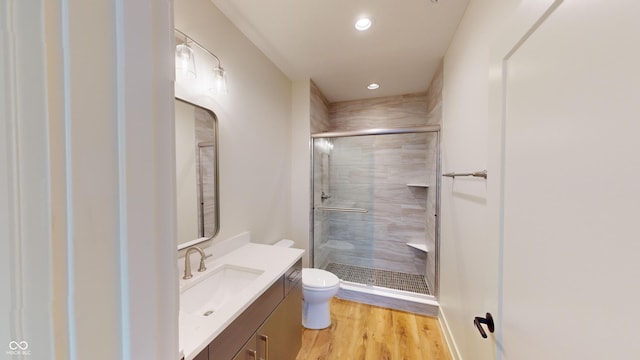 bathroom with vanity, toilet, walk in shower, and hardwood / wood-style floors