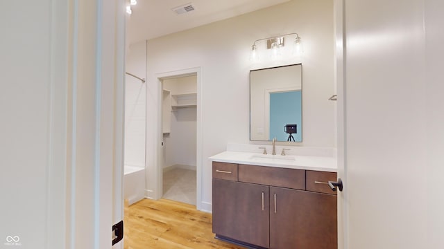 bathroom featuring a tub, hardwood / wood-style floors, and vanity