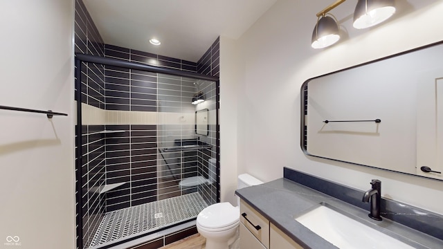 bathroom featuring vanity, toilet, and a shower with door