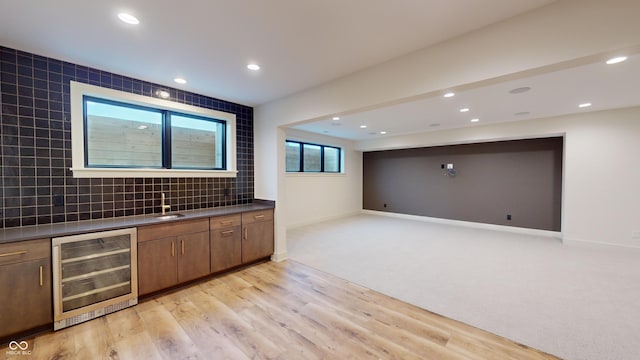 bar with sink, light colored carpet, wine cooler, and decorative backsplash