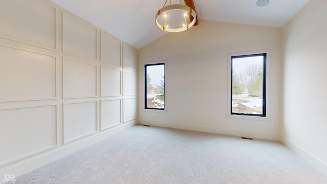 spare room with lofted ceiling and light carpet