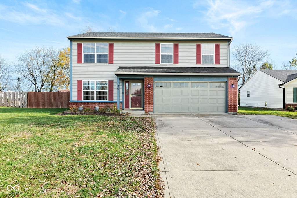 view of property featuring a front lawn and a garage