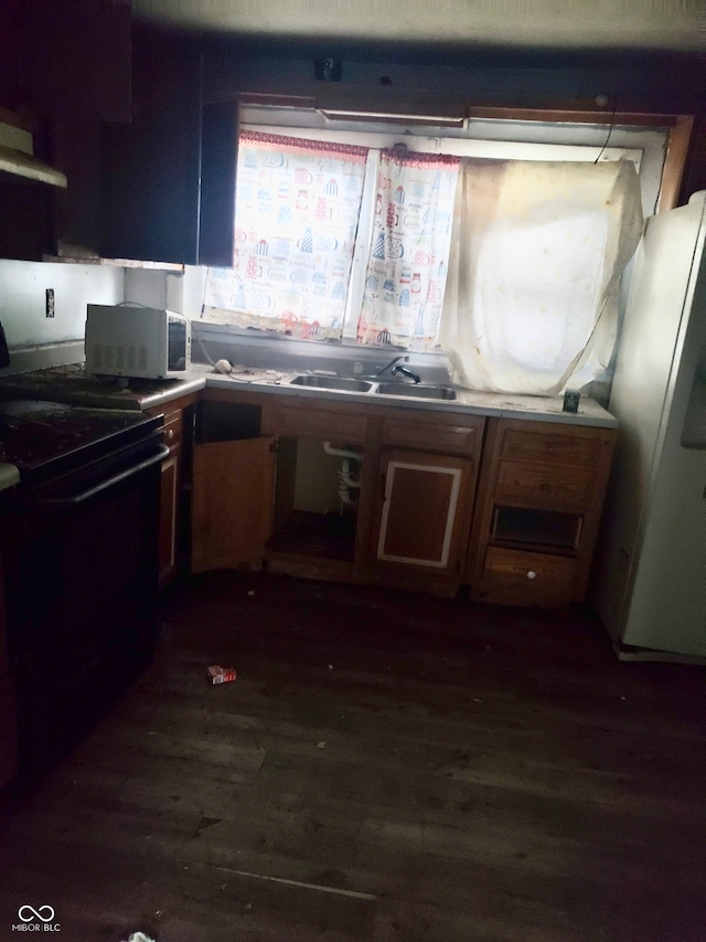 kitchen featuring black stove, dark wood-type flooring, sink, and white fridge